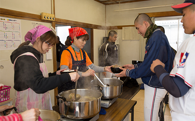 保護者が当番制で作る炊き出しを食べる福岡工業野球部の選手達